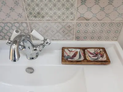 a bathroom sink with a faucet and a tray on it at West End in Woodbridge
