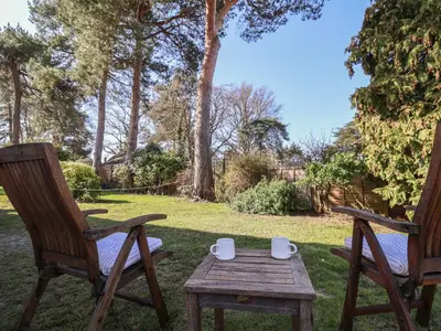 two chairs and a wooden table in a yard at West End in Woodbridge