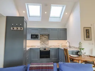 a kitchen with blue cabinets and a table with a blue couch at West End in Woodbridge