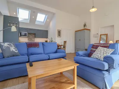 a living room with blue couches and a table at West End in Woodbridge