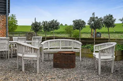 a group of white chairs and tables and trees at The Hare's Field, Wethersfield in Wethersfield