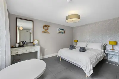 a bedroom with a large bed and a mirror at The Hare's Field, Wethersfield in Wethersfield