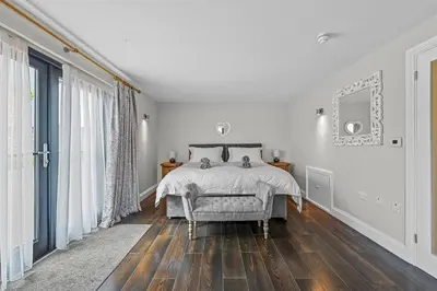 a white bedroom with a bed and a large window at The Hare's Field, Wethersfield in Wethersfield