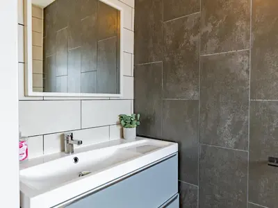 a bathroom with a white sink and a mirror at Hawkwell Retreat 5 Bedroom home Hockley - Pass the Keys in Hawkwell