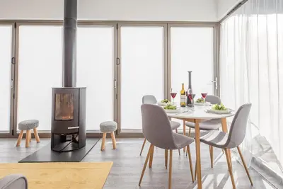 a dining room with a table and chairs and a wood stove at The Haywain, Flatford in East Bergholt