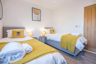a bedroom with two beds with yellow sheets at The Haywain, Flatford in East Bergholt