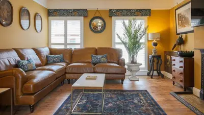 a living room with a brown leather couch at Paradise Penthouse in Downham Market