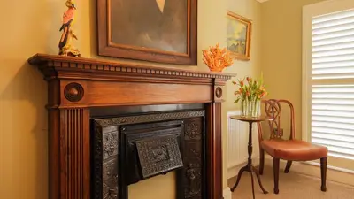 a fireplace in a room with a chair and a picture at Paradise Penthouse in Downham Market