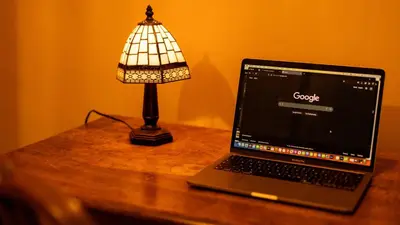 a laptop computer sitting on a table next to a lamp at Paradise Penthouse in Downham Market