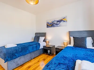 a bedroom with two beds and a couch at Hawkwell Hideaway Large 4 bedroom Home Hockley - Pass the Keys in Hawkwell