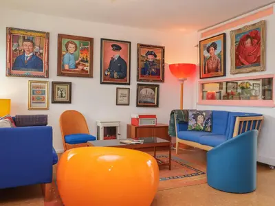 a living room with a orange couch and chairs at The Orchard Close Art House in Great Livermere