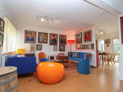 a living room with blue and orange furniture and a table at The Orchard Close Art House in Great Livermere