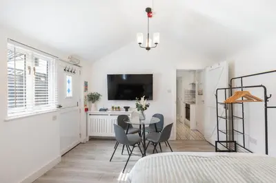 a bedroom with a table and chairs and a bed at Chandini Villa in High Wych in Sawbridgeworth
