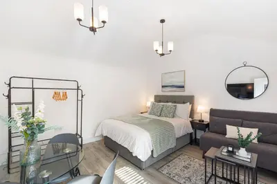a bedroom with a bed and a couch at Chandini Villa in High Wych in Sawbridgeworth