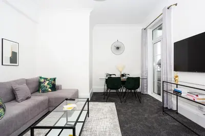 a living room with a couch and a tv at Ocean Breeze in Thorpe Bay