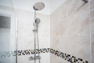a shower with a shower head in a bathroom at Ocean Breeze in Thorpe Bay