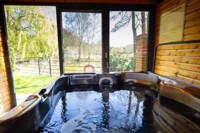 a pool of water in a house with windows at Tewinbury Farm Hotel in Tewin