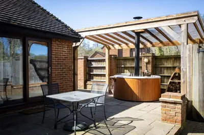 a patio with a grill and a wooden pergola at Tewinbury Farm Hotel in Tewin