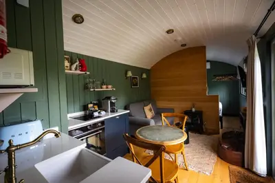 a kitchen with green walls and a table in a room at Tewinbury Farm Hotel in Tewin