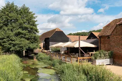 a restaurant with a pond in front of a building at Tewinbury Farm Hotel in Tewin