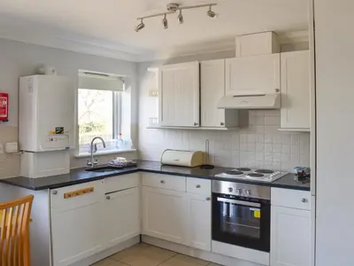 a kitchen with white cabinets and black counter tops at Thistle No4 - Uk49250 in Althorne