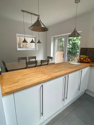 a kitchen with white cabinets and a wooden counter top at 4 Bedroom Detached House Sleeps 7 in Ipswich