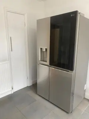 a large silver refrigerator with a television in a room at 4 Bedroom Detached House Sleeps 7 in Ipswich