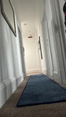 a hallway with a blue rug in a room at Seaside Escape in Thorpe Bay