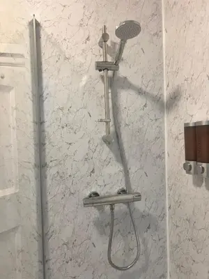 a shower head on a wall in a bathroom at Seaside Escape in Thorpe Bay
