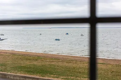 a window view of the ocean with boats in the water at Seaside Escape in Thorpe Bay
