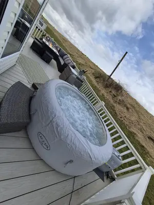 a boat sitting on the porch of a house at The Blue Lagoon 2 bedroom lodge with hot tub in Walton-on-the-Naze