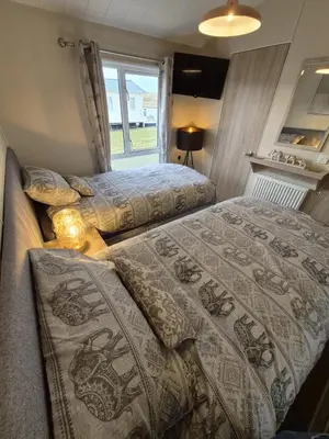 a bedroom with two beds and a window at The Blue Lagoon 2 bedroom lodge with hot tub in Walton-on-the-Naze