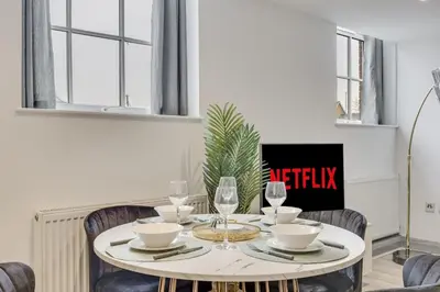a dining room table with chairs and a table with wine glasses at Stylish stay Ware town with parking in Ware