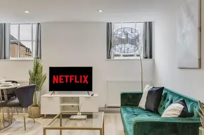 a living room with a green couch and a television at Stylish stay Ware town with parking in Ware