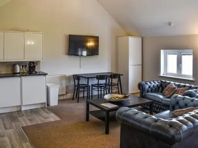 a living room with couches and a table and a kitchen at Periwinkle No5 - Uk49249 in Althorne