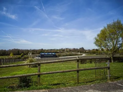a fence in a field with a train in the distance at Periwinkle No5 - Uk49249 in Althorne