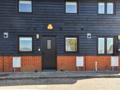 a blue building with a black door and windows at Holly No2 - Uk49254 in Althorne