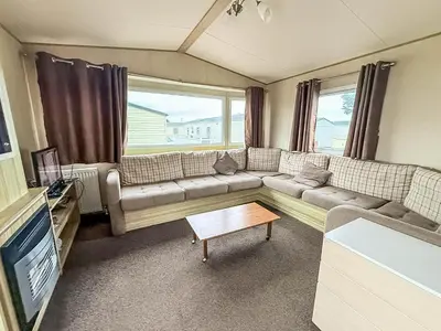 a living room with a couch and a table at 6 Berth Caravan With Side Decking At Suffolk Sands Holiday Park Ref 45054C in Felixstowe