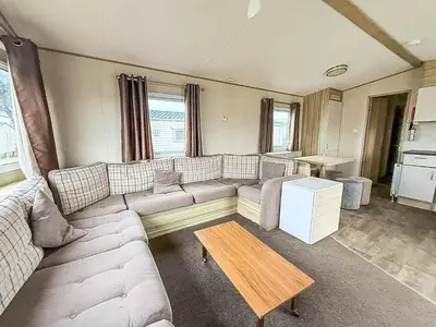 a living room with a couch and a table at 6 Berth Caravan With Side Decking At Suffolk Sands Holiday Park Ref 45054C in Felixstowe