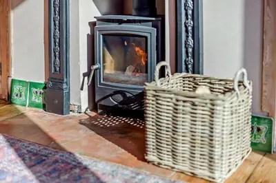 a fireplace with a wicker basket in front of it at 2 Bed in Holbrook oc-31111 in Holbrook