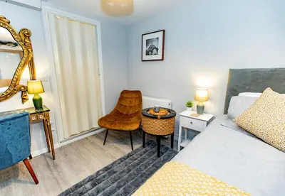 a bedroom with a bed and a table and a chair at The Serene Suite Brandon in Brandon