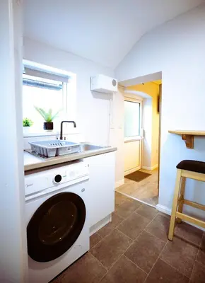 a kitchen with a washing machine and a sink at The Serene Suite Brandon in Brandon