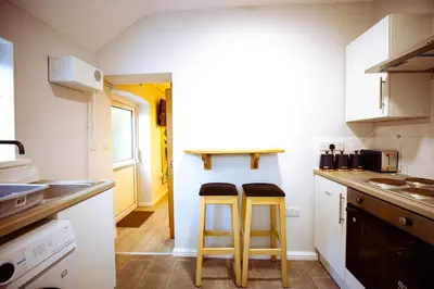 a kitchen with two stools in front of a counter at The Serene Suite Brandon in Brandon