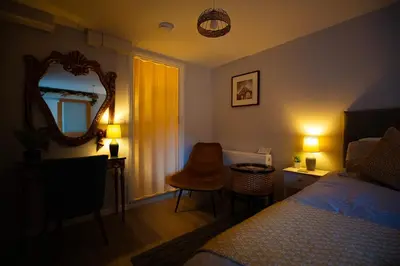 a bedroom with a bed and a mirror and a chair at The Serene Suite Brandon in Brandon
