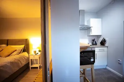 a bedroom with a bed and a small kitchen at The Serene Suite Brandon in Brandon