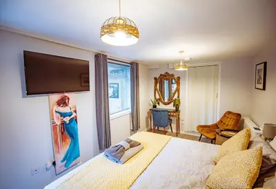 a bedroom with a large bed with a picture on the wall at The Serene Suite Brandon in Brandon