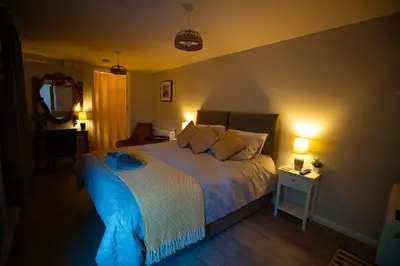 a bedroom with a bed with a blue comforter at The Serene Suite Brandon in Brandon