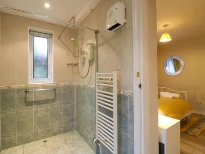 a bathroom with a shower with a glass door at Crown Farm in Wisbech