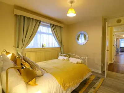 a bedroom with a large bed with a yellow bedspread at Crown Farm in Wisbech