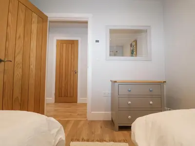 a bedroom with a bed and a dresser and a mirror at Bradley's Barn in Colchester